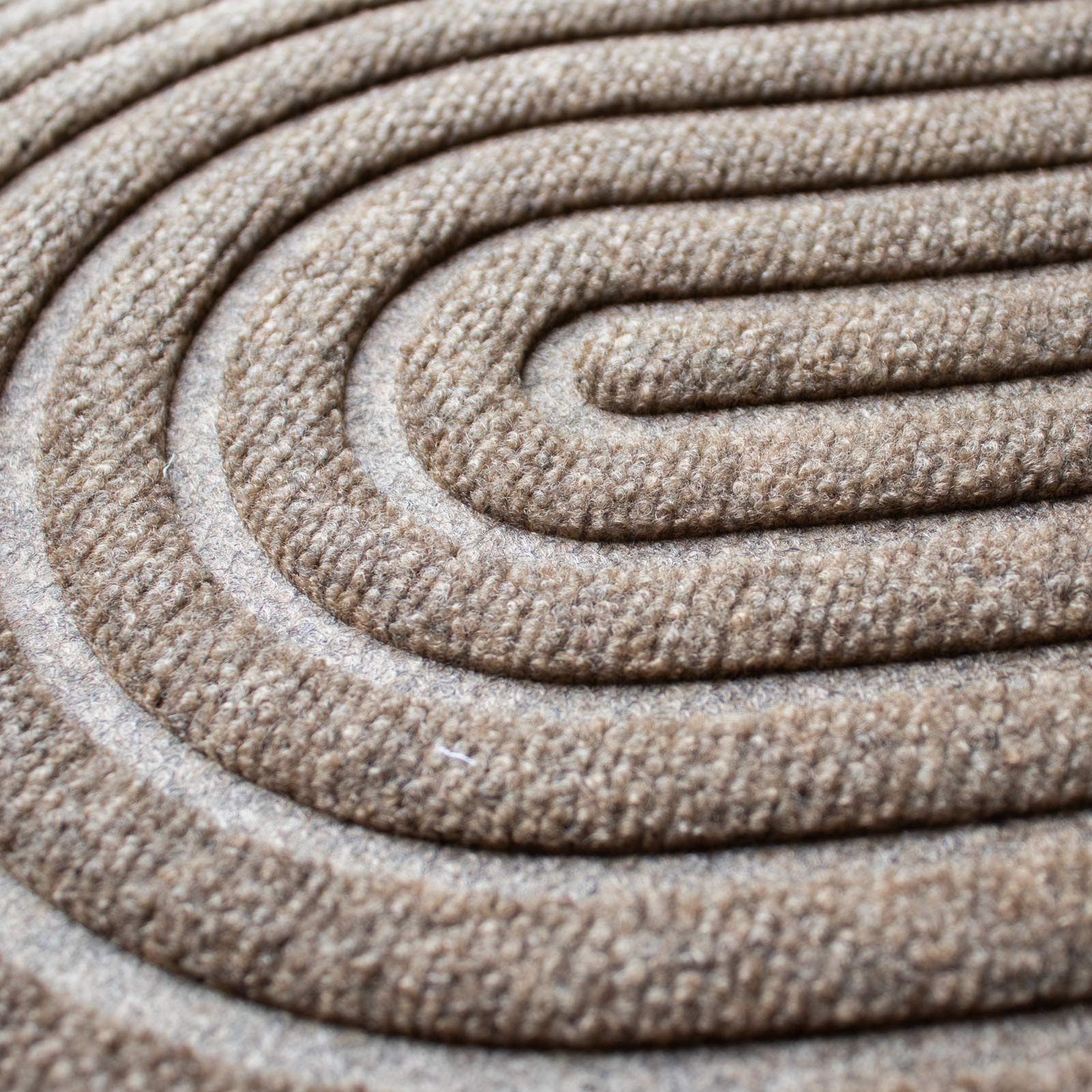 Close-up of a beige doormat with an organic pattern