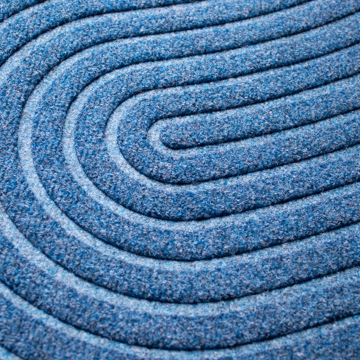 Close-up of blue textured doormat with concentric circles