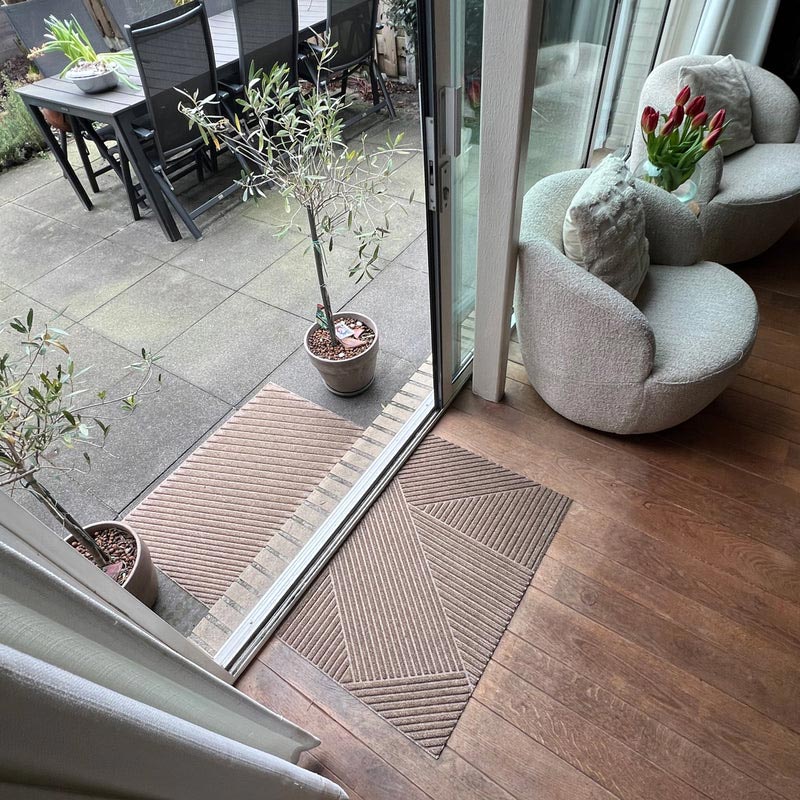 Living room with a sliding glass door leading to an outdoor area, featuring a rug and decorative items.